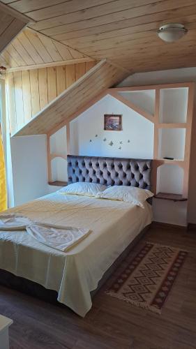 a large bed in a room with a wooden ceiling at Casa Sara in Eforie Nord