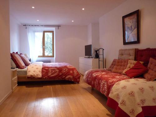 - une chambre avec 2 lits, un canapé et une télévision dans l'établissement Domaine de la Safranière - Chambre d'hote, à Saint-Léger