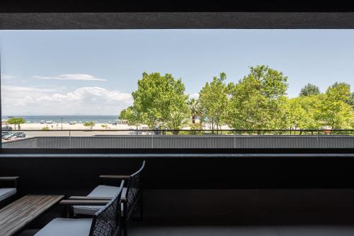 a restaurant with benches and a view of the ocean at ZOI Girni - Seaside Hotel in Olympic Beach