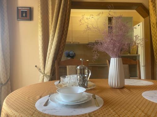 a table with a bowl and a vase on it at SUNLUX Seaview Apartment in Đenovići