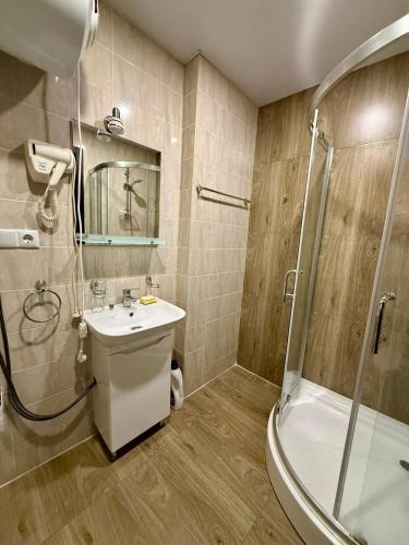 a bathroom with a shower and a sink and a tub at Apart Hotel TRIBU Bakuriani in Bakuriani