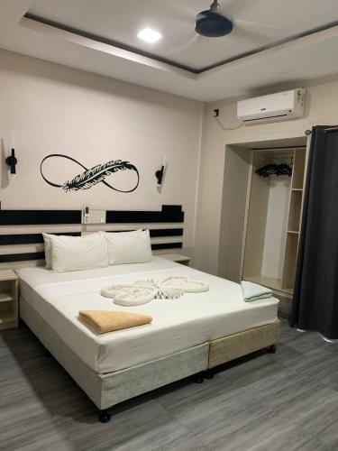 a bedroom with a large white bed with a fish on the wall at Seaside Villa in Dhiffushi