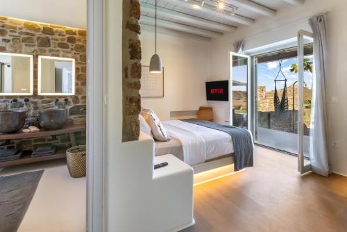 a bedroom with a bed and a stone wall at Villa RED VENUS in Kalafatis
