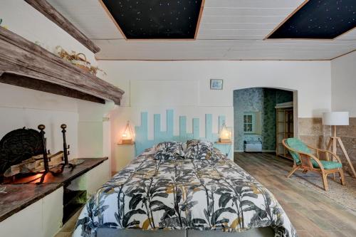 a bedroom with a bed and a chair in it at lemasrocamour in Roquemaure