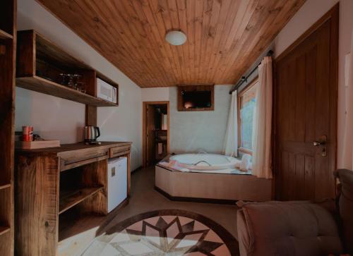 a bathroom with a bed and a tub in a room at Hotel Cabanas Glamour in Gramado