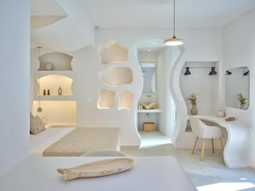 a white room with a bed and a desk at Rocaia Mini Suites Naousa in Naousa