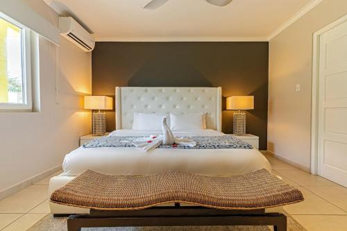 a bedroom with a large white bed with two lamps at Only 350 yards from Eagle Beach! in Palm-Eagle Beach