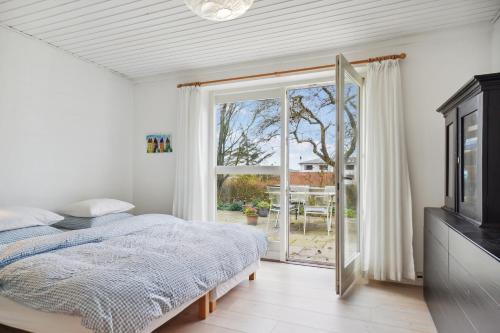 a bedroom with a bed and a sliding glass door at Brøndums B & B in Hjørring