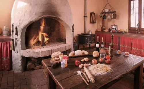 cocina con horno de piedra y mesa con comida en La Negrita Casa de Campo en Azcuénaga