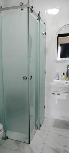 a bathroom with a glass shower and a toilet at appartement forêt diplomatique in Tangier