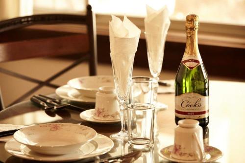 a bottle of champagne on a table with plates and glasses at Hotel Quinta Mision in Creel