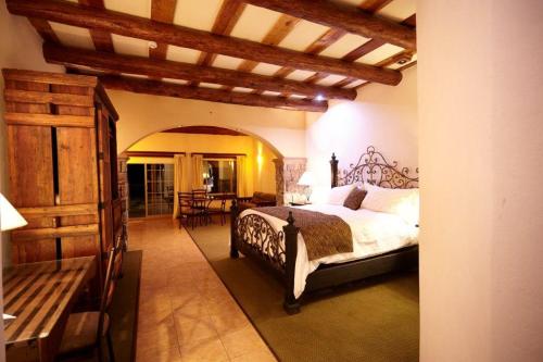 a bedroom with a bed and a room with a table at Hotel Quinta Mision in Creel