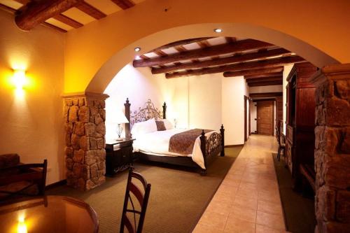 a bedroom with a bed in a room with an archway at Hotel Quinta Mision in Creel