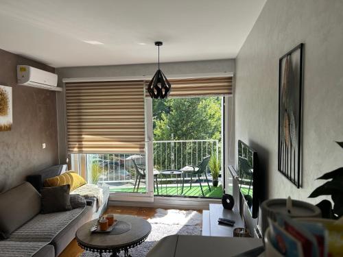a living room with a couch and a view of a balcony at CENTRAL POINT APARTMENT - City centar Zenica- in Zenica