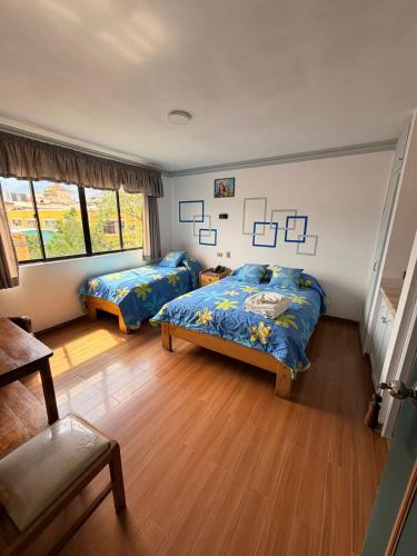 ein Schlafzimmer mit zwei Betten und einem Stuhl in der Unterkunft City Hotel in Cochabamba