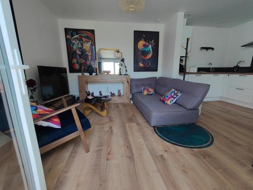 a living room with a couch and a table at Maison chic & chill in Saint-Brieuc