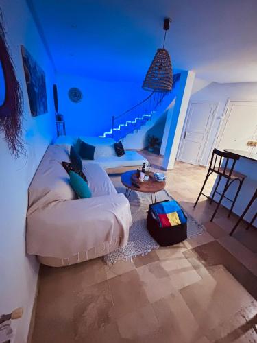 a living room with a white couch and a table at Charmant duplex proche mer à Carthage in Carthage
