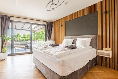 a large bed in a bedroom with a large window at Elite House Gold Apartment in Leányfalu