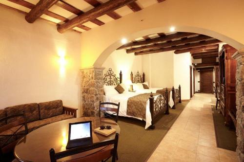 a bedroom with a bed and a table in a room at Hotel Quinta Mision in Creel