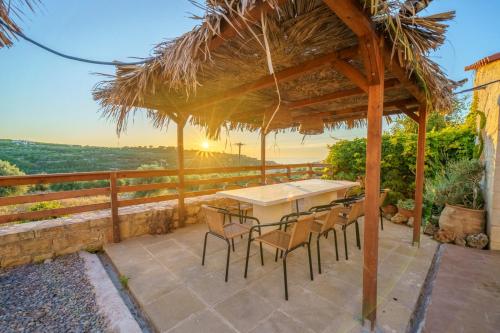 a table and chairs on a patio with the sunset at Fisi & Wellness Exclusive Villa with Spa Vibes in Stavromenos