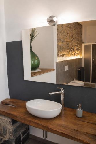 a bathroom with a sink and a vase on a counter at Lescen White Residence - swimming pool in Lezzeno