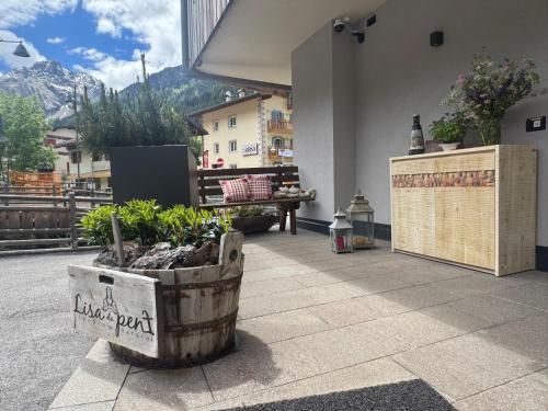a patio with some plants in a wooden barrel at Lisa Da Pent in Canazei
