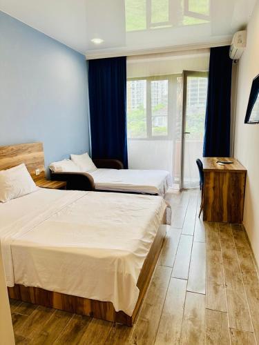 a hotel room with two beds and a window at Aparthotel costa in Makhinjauri