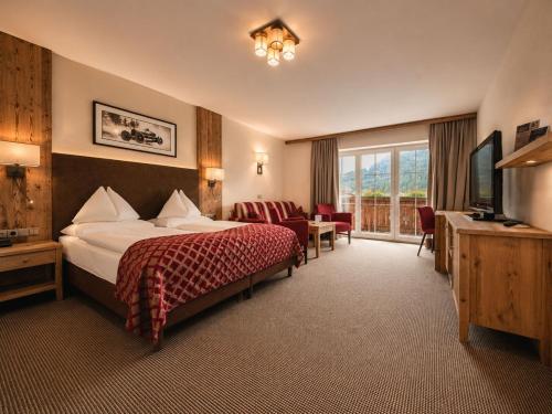a hotel room with a bed and a television at Hotel Das Urbisgut in Altenmarkt im Pongau
