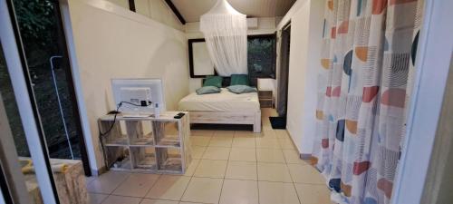 a small room with a bed and a table at Kaz l'Oranger in Saint Esprit