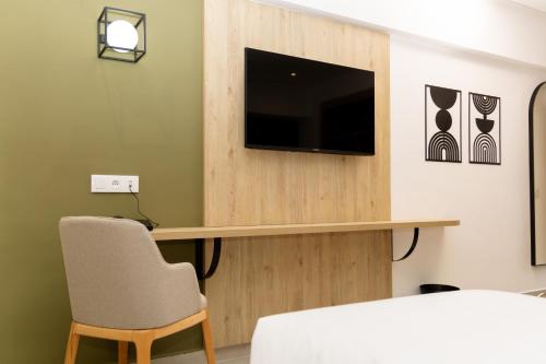a room with a tv and a table and a chair at HOTEL KAMAL CITY CENTER in Agadir