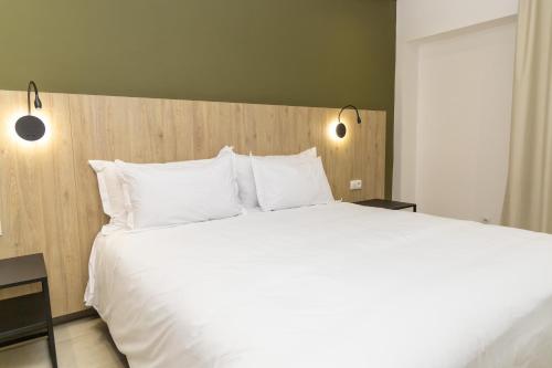 a large bed with white pillows in a bedroom at HOTEL KAMAL CITY CENTER in Agadir