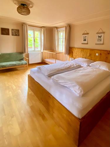 a large bedroom with a large bed with white sheets at Villa Zeppelin - App Aquamarin in Bramberg am Wildkogel