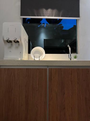 a kitchen counter with a sink and a microwave at The Lumber with Private Pool in Masjid Tanah
