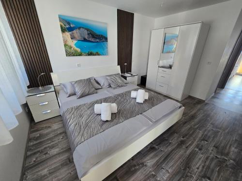 a bedroom with a large bed with two white towels at Villa Rocco Private Saltwater Pool Split in Kaštela