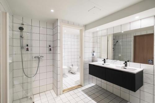 Vøringfoss Hotel في إيدفيورد: حمام مزود بمغسلة ودش ومرحاض
