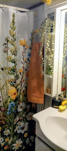 a bathroom with a shower curtain with flowers on it at Phedra's House Spata- Artemida in Artemida