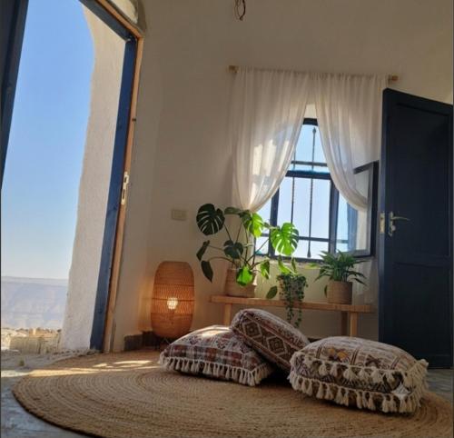 a bedroom with a bed and a large window at Tootya camp in Al Mathlūthah