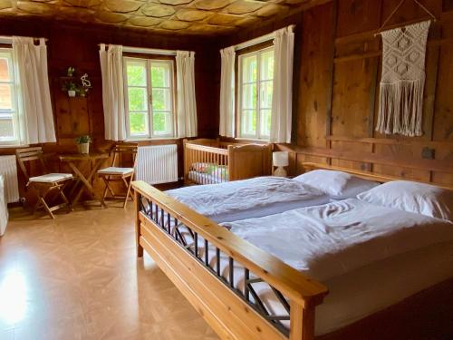 a bedroom with a large bed in a room with windows at Villa Zeppelin - App Bergkristall in Bramberg am Wildkogel