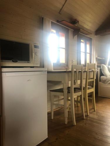 a kitchen with a table with chairs and a microwave at Chaloupka Bečov in Blatno