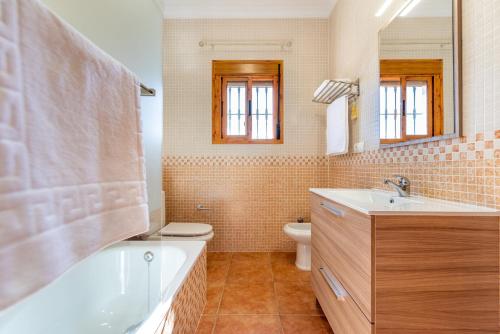 a bathroom with a tub and a toilet and a sink at Casa Mari in Almogía