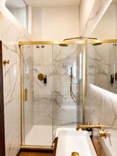 a bathroom with a shower and a white sink at Apartamentos El Capitan in Potes
