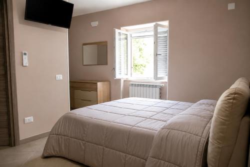 a bedroom with a bed and a window at Merus in Faicchio