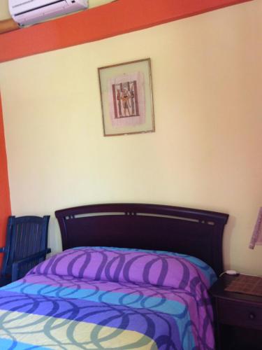 a bedroom with a bed and a picture on the wall at Hostal Surf Olón in Olón