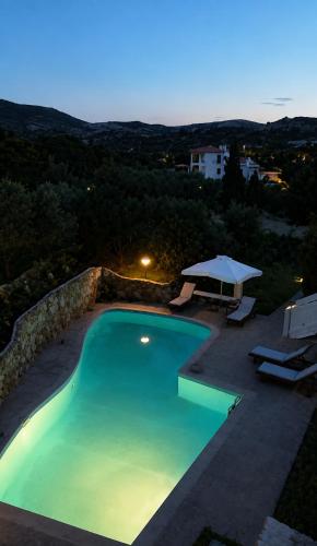 a large swimming pool with a table and chairs at Villa Evmaria in Áyios Konstandínos