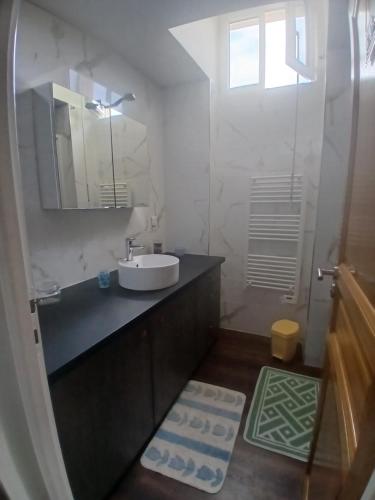 a white bathroom with a sink and a mirror at Petit bien in Marcillac