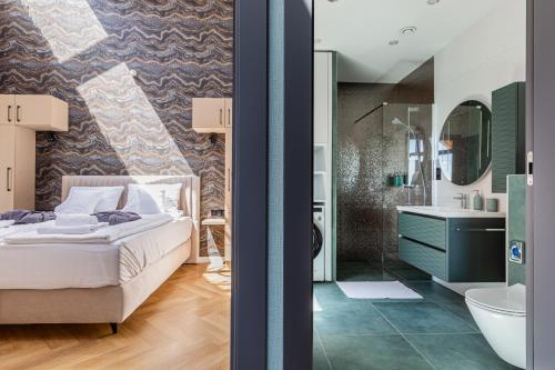 a bedroom with a bed and a bathroom at Elite House Platina Apartment in Leányfalu