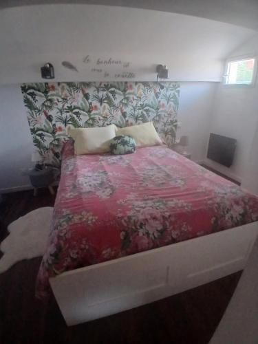 a bedroom with a bed with a red comforter at Petit bien in Marcillac