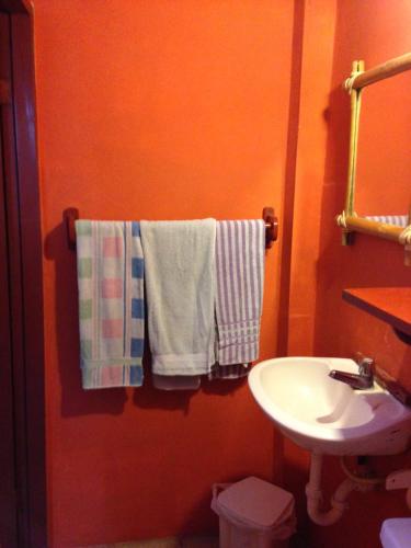 a bathroom with a sink and towels on a rack at Hostal Surf Olón in Olón