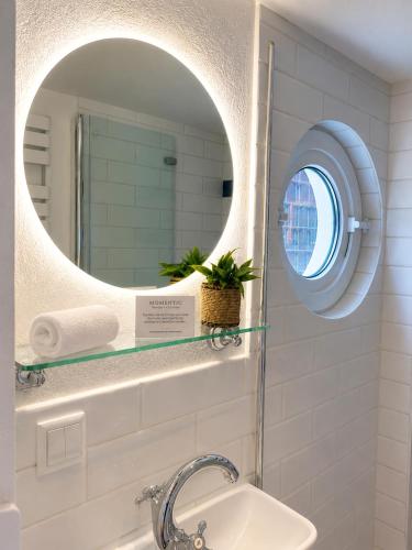 a bathroom with a sink and a mirror at Kajüte mit Meerblick & eigener Terrasse in Sierksdorf