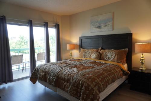 a bedroom with a large bed and a balcony at River Place Condos #410 3BD in Pigeon Forge
